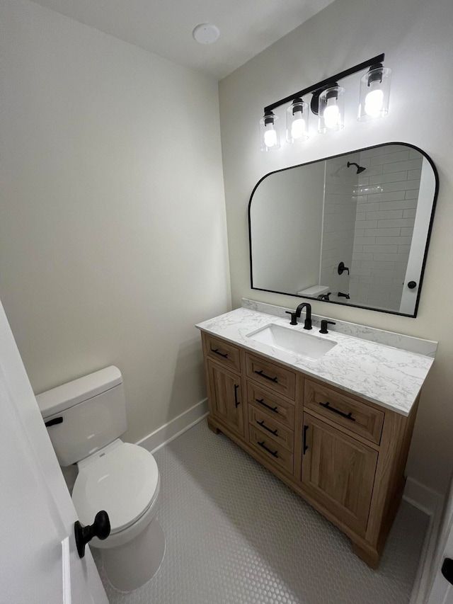 bathroom featuring tiled shower, vanity, toilet, and tile patterned floors