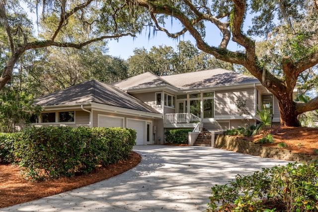 view of front of property featuring an attached garage, driveway, stairs, and a porch