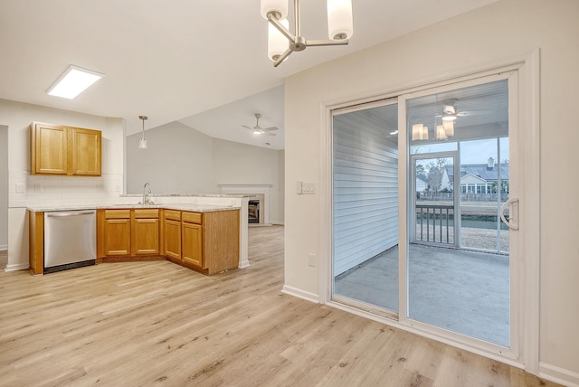 kitchen featuring light wood-type flooring, dishwasher, hanging light fixtures, and a peninsula