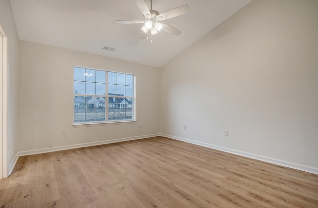 empty room featuring visible vents, vaulted ceiling, light wood-type flooring, and a ceiling fan