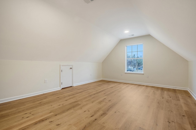 bonus room with light wood-type flooring, visible vents, lofted ceiling, and baseboards