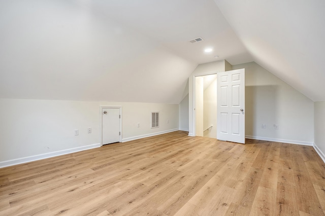 bonus room with lofted ceiling, baseboards, visible vents, and light wood-style floors