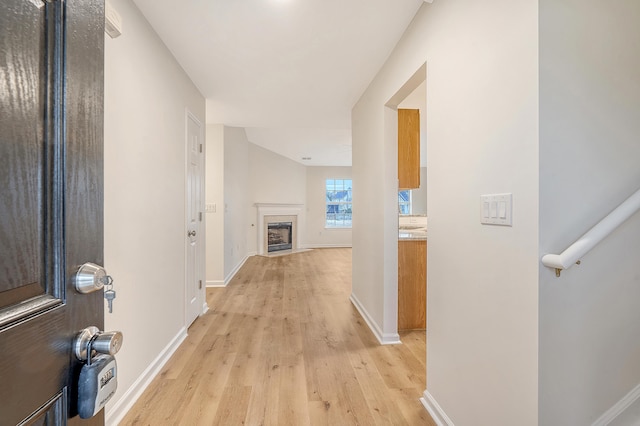 hall with light wood finished floors and baseboards