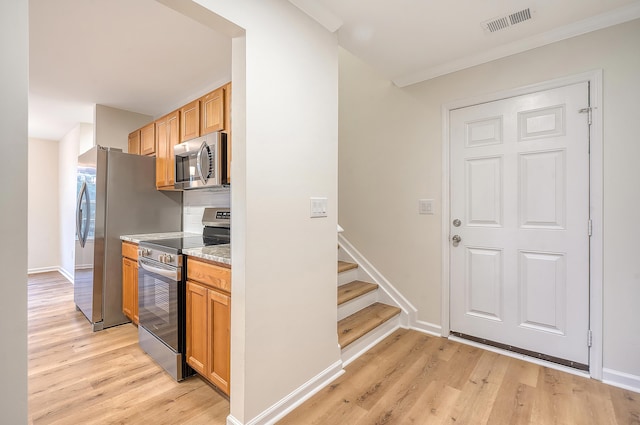 kitchen with baseboards, visible vents, stainless steel appliances, crown molding, and light wood-type flooring