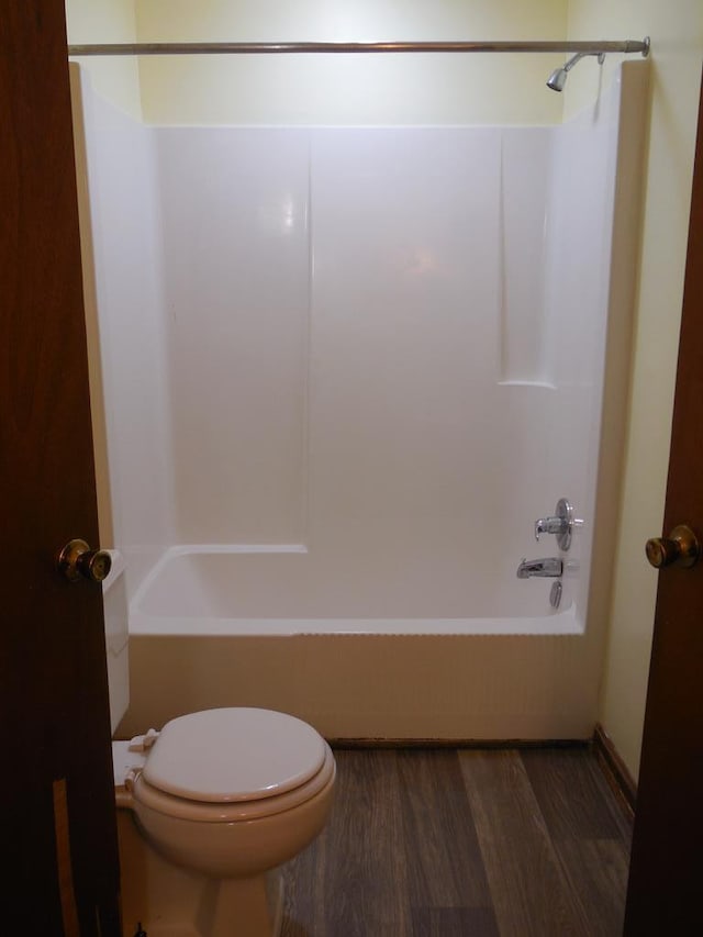 bathroom featuring shower / bath combination, toilet, and wood-type flooring