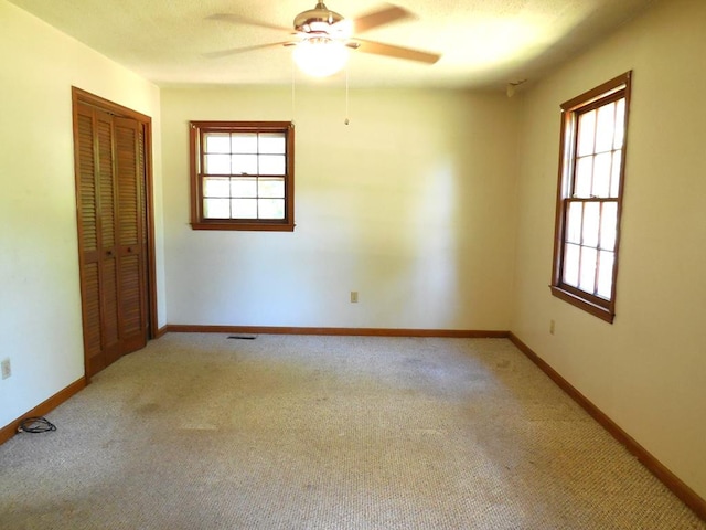 carpeted spare room featuring ceiling fan