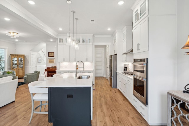 kitchen featuring hanging light fixtures, white cabinetry, appliances with stainless steel finishes, and sink