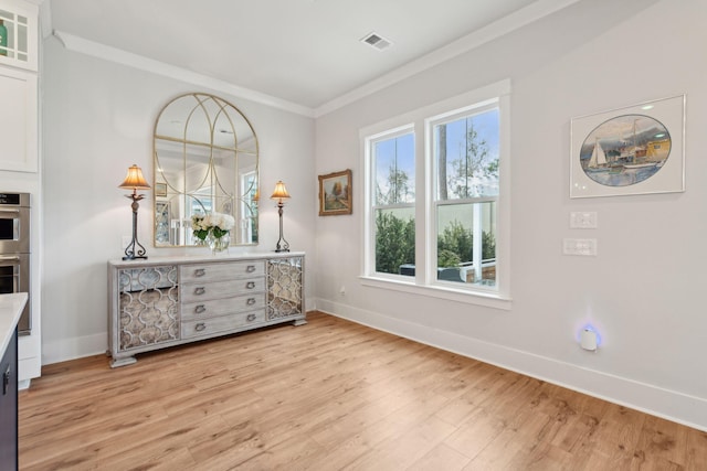 interior space featuring ornamental molding and light hardwood / wood-style flooring