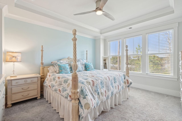 bedroom with a raised ceiling, ornamental molding, light colored carpet, and multiple windows