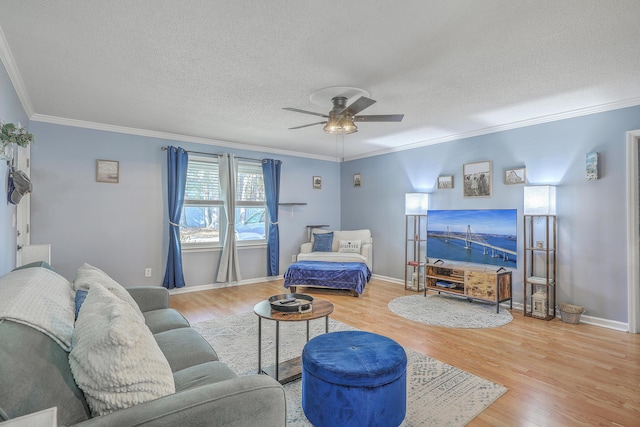 living room featuring a ceiling fan, wood finished floors, a textured ceiling, and crown molding