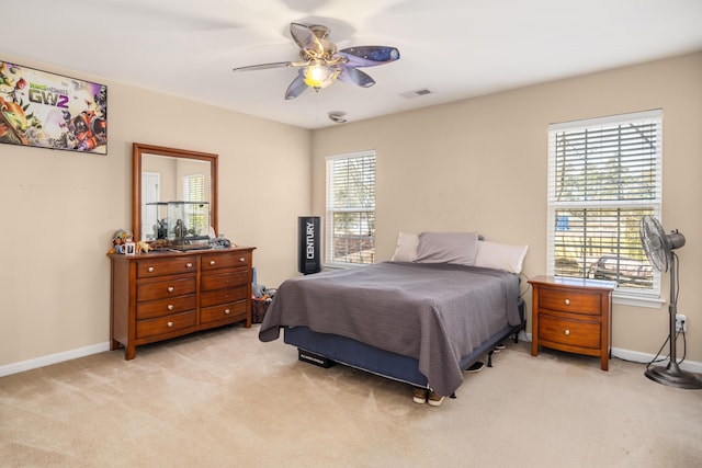 carpeted bedroom with multiple windows and ceiling fan