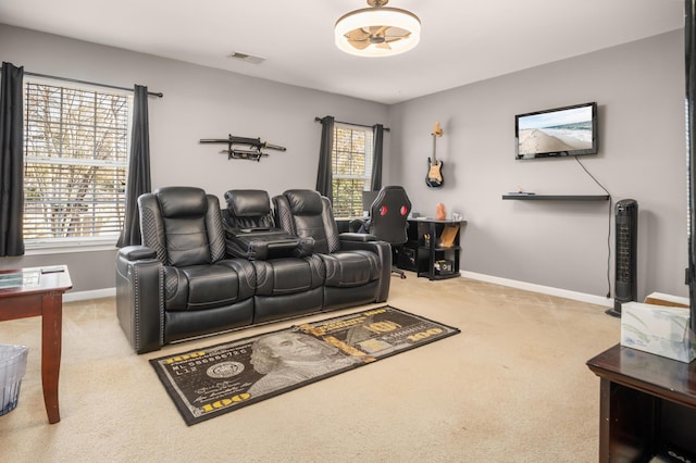 home theater room with a healthy amount of sunlight and light carpet