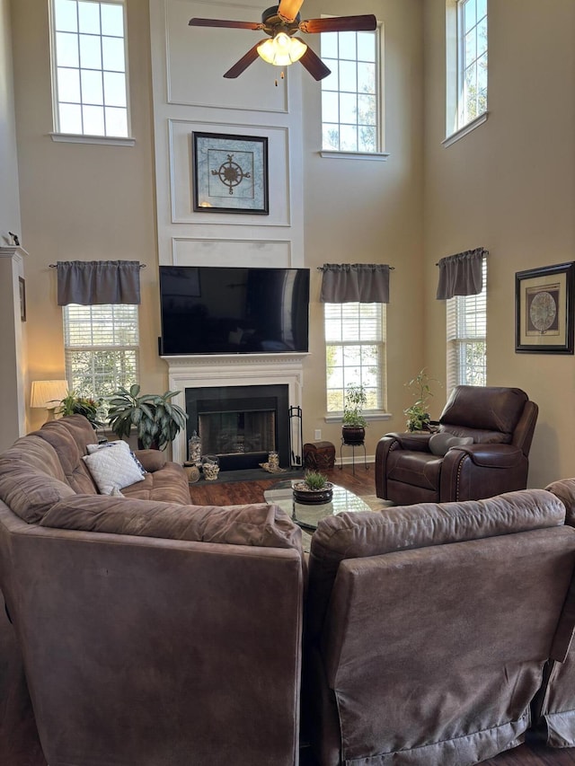 living room with a towering ceiling and ceiling fan