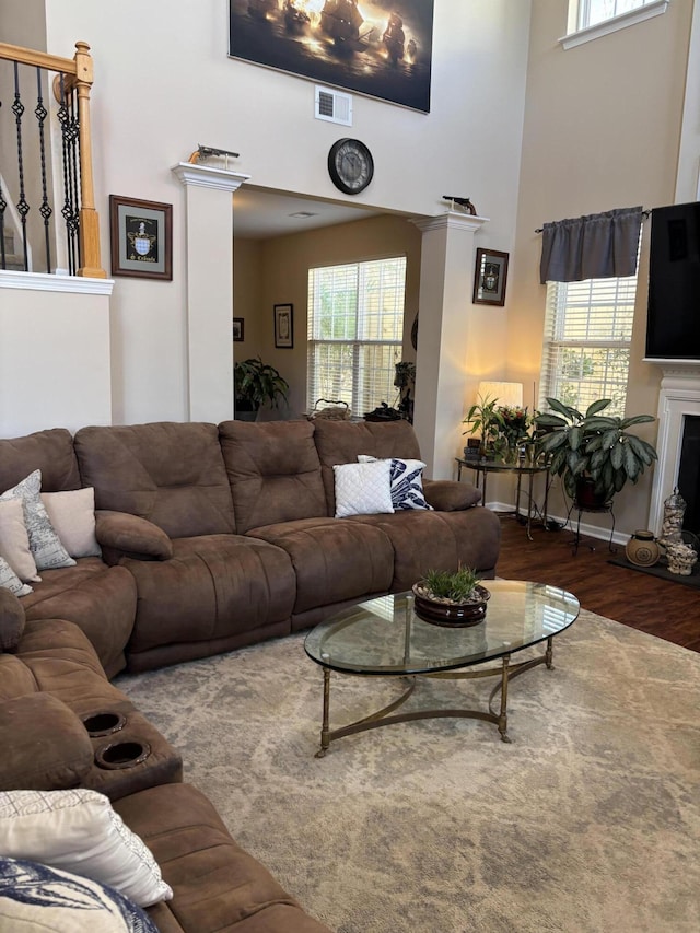 living room with a towering ceiling and dark hardwood / wood-style floors