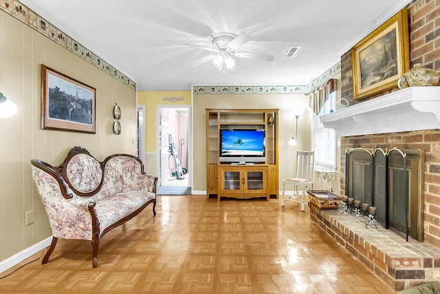 sitting room featuring a brick fireplace, ceiling fan, and light parquet floors