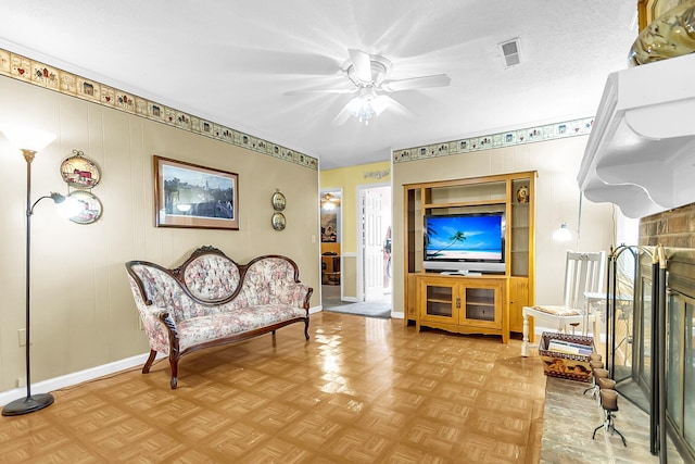 living area with light parquet flooring, a textured ceiling, and ceiling fan