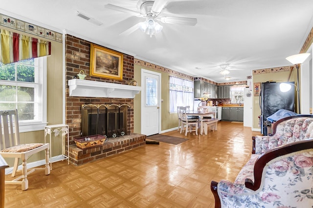 living room with ceiling fan, parquet flooring, crown molding, and a brick fireplace