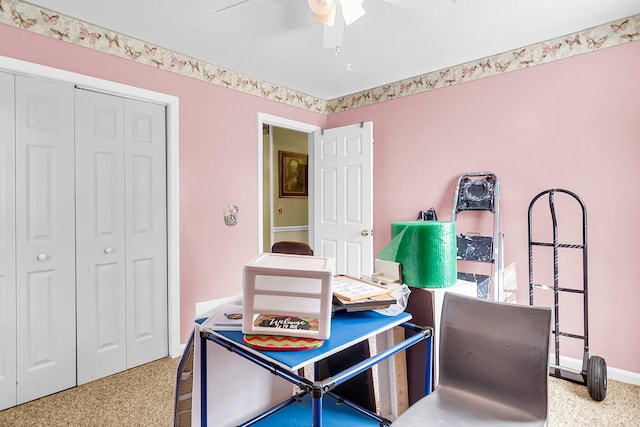 carpeted home office featuring ceiling fan