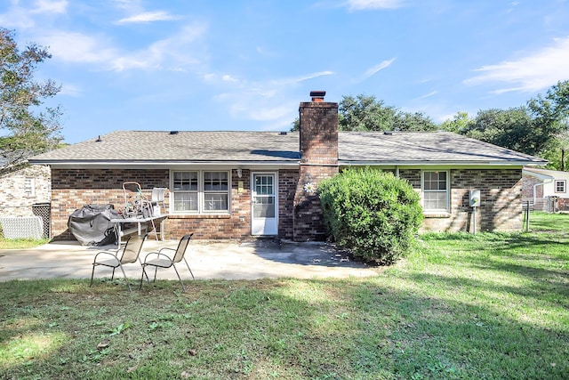 rear view of house featuring a patio and a yard