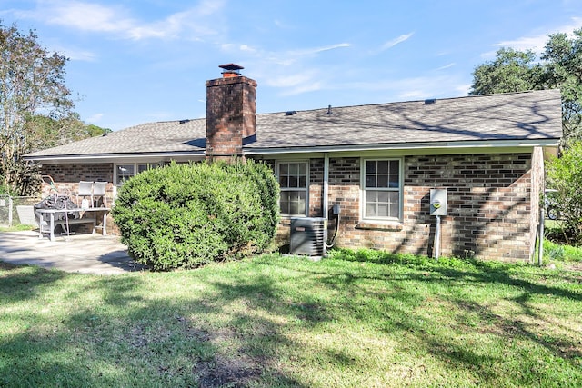 rear view of house with a patio, a yard, and central air condition unit