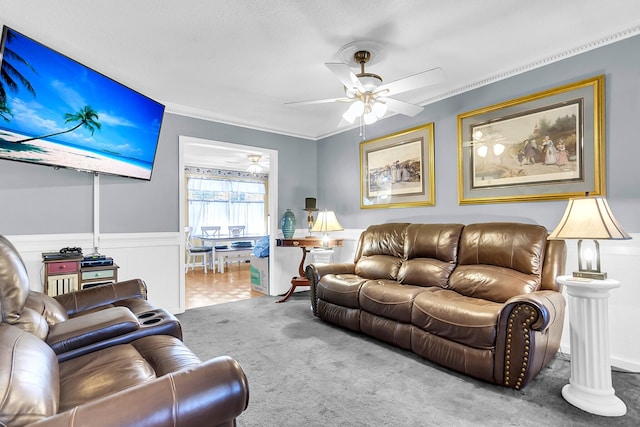 carpeted living room featuring ceiling fan and ornamental molding