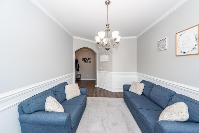 living room featuring crown molding, a chandelier, and light wood-type flooring