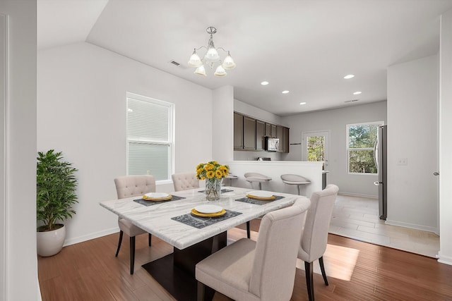 dining room featuring baseboards, an inviting chandelier, wood finished floors, and recessed lighting