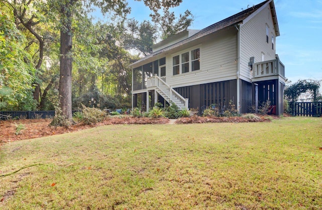 back of house with a sunroom and a yard