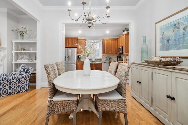 dining area with a notable chandelier, light wood-type flooring, and crown molding