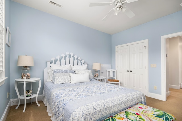 carpeted bedroom with ceiling fan and a closet