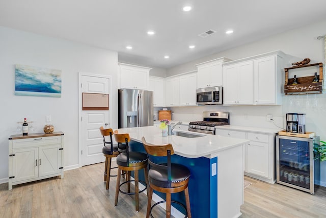 135 Cypress Preserve Blvd, Moncks Corner, SC 29461 - kitchen featuring appliances with stainless steel finishes, wine cooler, a sink, light wood-style flooring, and recessed lighting