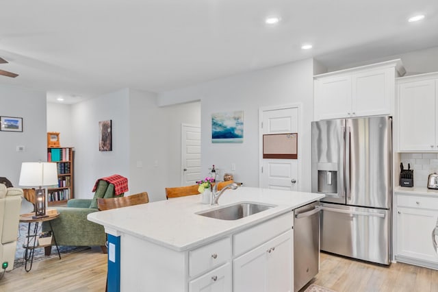 135 Cypress Preserve Blvd, Moncks Corner, SC 29461 - kitchen with appliances with stainless steel finishes, a sink, light wood-style flooring, open floor plan, and white cabinets