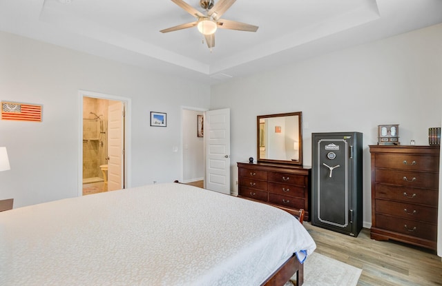 135 Cypress Preserve Blvd, Moncks Corner, SC 29461 - bedroom with a tray ceiling, light wood-style flooring, ensuite bath, and a ceiling fan