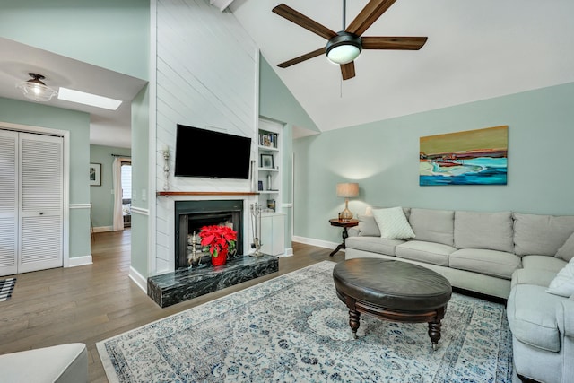 living room with a premium fireplace, hardwood / wood-style floors, high vaulted ceiling, and ceiling fan