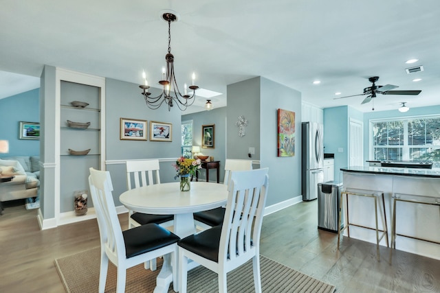 dining room featuring dark hardwood / wood-style floors and ceiling fan with notable chandelier