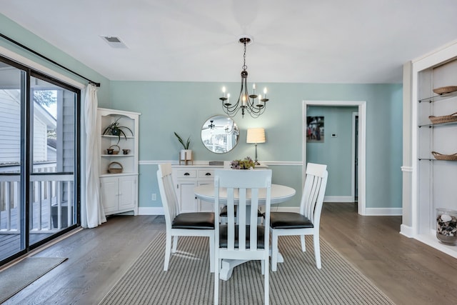 dining space featuring dark hardwood / wood-style flooring and a chandelier