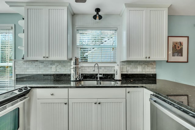 kitchen featuring white cabinets, dark stone countertops, sink, and appliances with stainless steel finishes