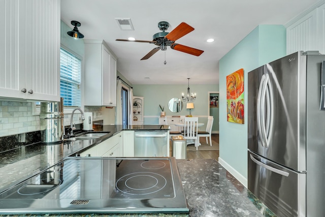 kitchen featuring appliances with stainless steel finishes, backsplash, sink, decorative light fixtures, and white cabinets