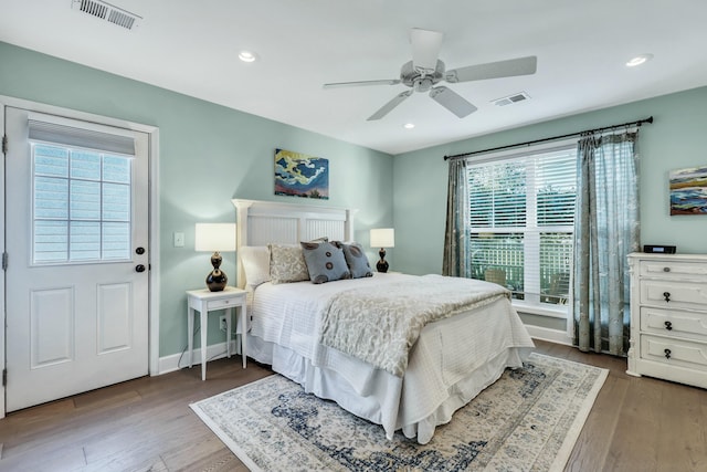 bedroom featuring hardwood / wood-style flooring, ceiling fan, and multiple windows