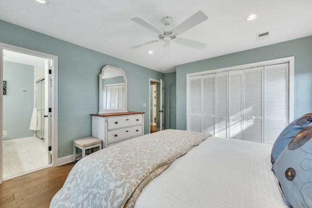 bedroom featuring a closet, hardwood / wood-style flooring, ceiling fan, and ensuite bathroom