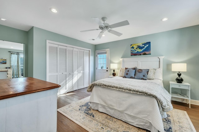 bedroom featuring a closet, dark hardwood / wood-style floors, and ceiling fan