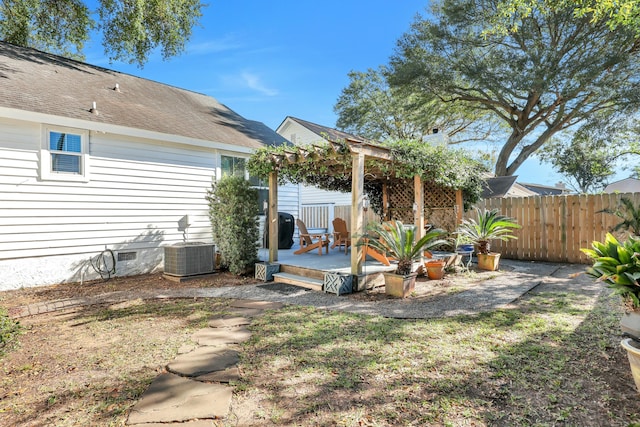 rear view of property with a pergola, central air condition unit, a yard, and a wooden deck