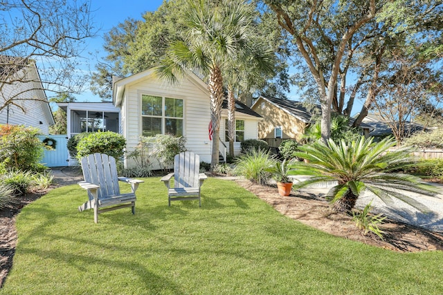 back of house with a lawn and a sunroom