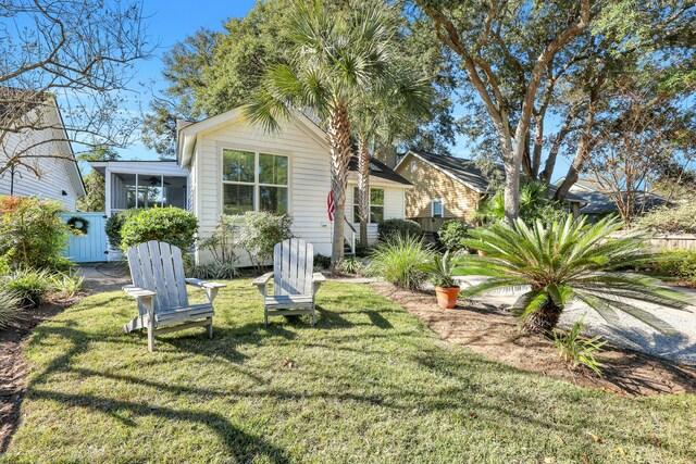 rear view of house with a sunroom and a yard