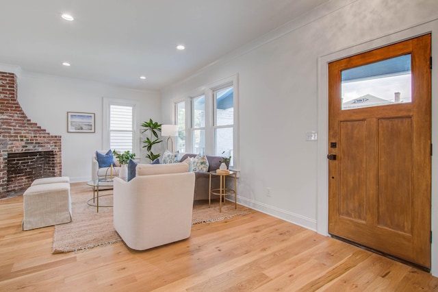 living room with light wood-style floors, recessed lighting, crown molding, and baseboards