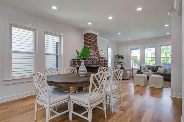 dining area featuring light wood finished floors, baseboards, crown molding, and recessed lighting