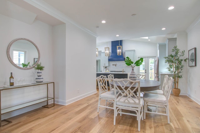 dining space featuring french doors, light wood-style floors, and a healthy amount of sunlight