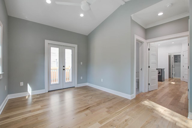 unfurnished room featuring light wood-type flooring, baseboards, vaulted ceiling, and french doors