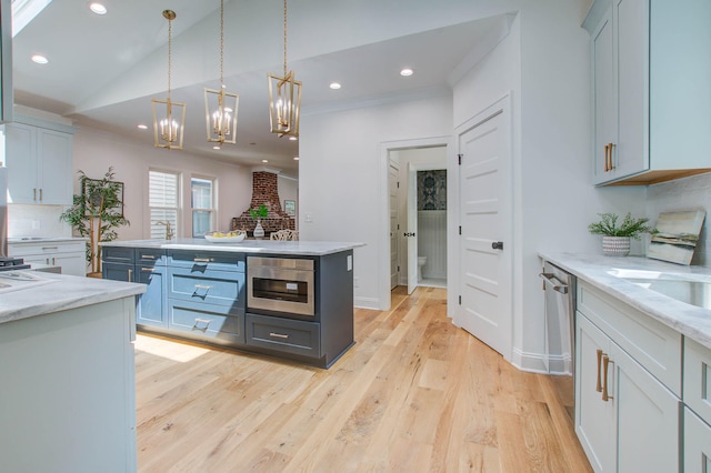 kitchen with light wood-style flooring, a kitchen island, hanging light fixtures, vaulted ceiling, and recessed lighting