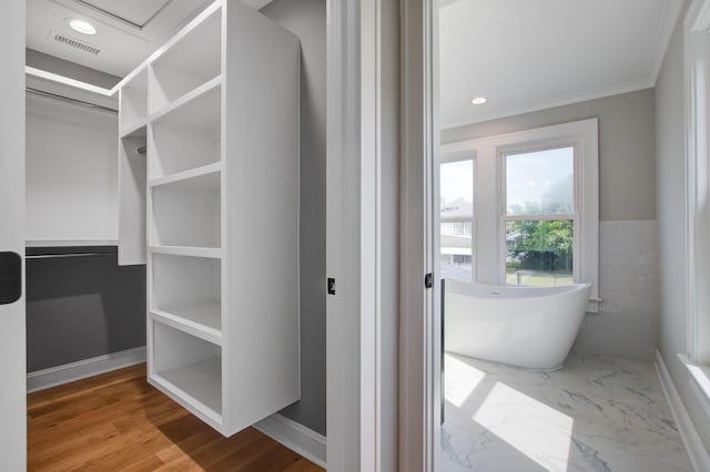 bathroom featuring visible vents, a soaking tub, marble finish floor, a spacious closet, and recessed lighting